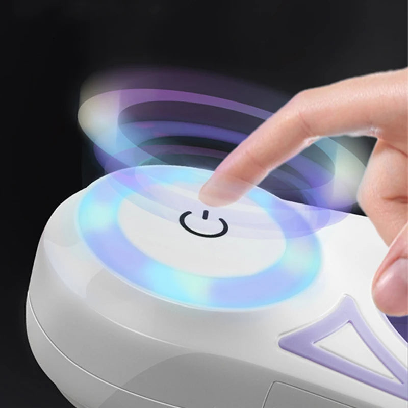 Hand pressing a button on a small, round electronic device with colorful lights.