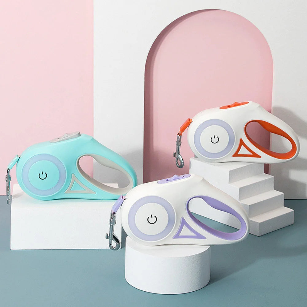 Two colorful pet leashes on cylindrical stands against a pink and gray background