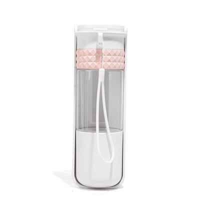 Clear water bottle with pink cap and white straw in packaging on a white background